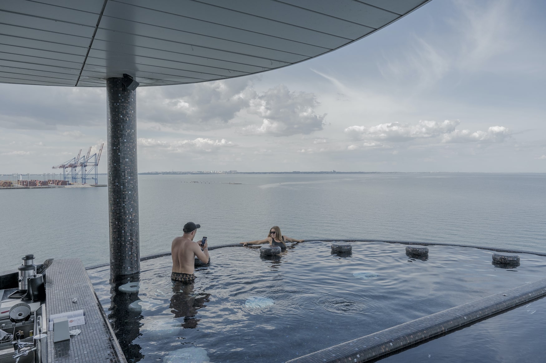Ein Paar in einem Infinity-Pool. Der Zugang zu den Stränden ist verboten und von russischen Raketen bedroht, Odesa, Ukraine, 25. Juni 2022 aus der Serie „Tributes to Odesa“ © Laetitia Vançon/LOBA 2023