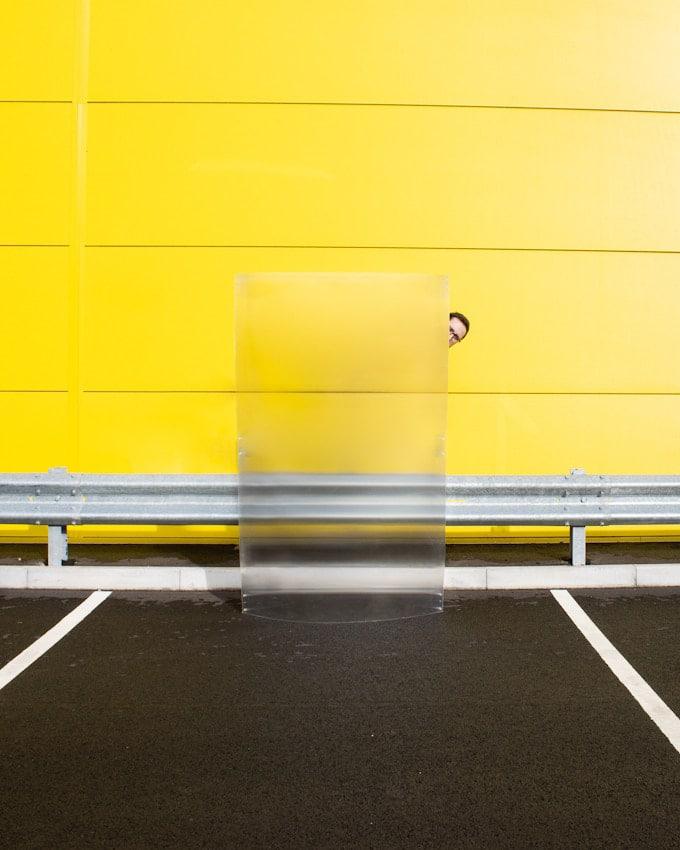 Invisibility Shield 2.0 vor einer gelben Wand an einem Parkplatz mit einer Leitplanke